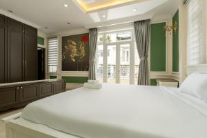 a bedroom with a large white bed and a window at Villa INDOCHINA 7 bed room in Ho Chi Minh City +32 photos