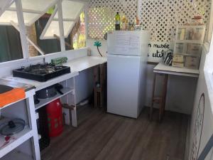 a small kitchen with a refrigerator and a stove at Fare Pū Tea in Rotoava