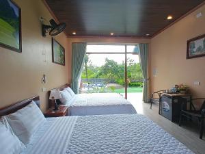 a hotel room with two beds and a large window at Hidden Rock Tam Coc in Vũ Lâm