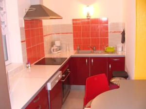 eine Küche mit einer Spüle und einem roten Stuhl in der Unterkunft Résidence Espinchal in Massiac