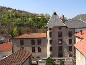 un antiguo edificio de piedra en una ciudad con casas en Résidence Espinchal en Massiac