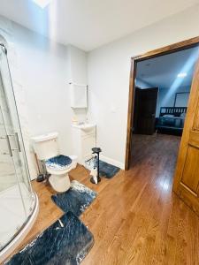 a bathroom with a toilet and two rugs on the floor at Cheerful 4-bedroom home with free parking in Elmont +16 photos