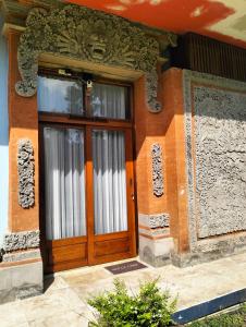 a building with a wooden door and windows at Villa Biyu siyu in Ubud
