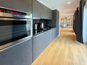 a kitchen with stainless steel appliances and a wooden floor at ImmoStay #3 - Penthouse mit zwei Balkonen & Seeblick, Parking & WiFi in Bremen