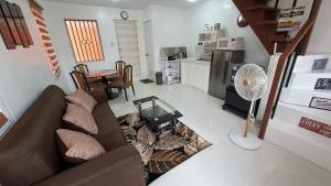 a living room with a couch and a table at House Brown style in Lipa