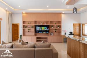 Bingin BeachにあるGovind Uluwatu Villa by Bukit Vistaのソファとテレビのあるリビングルーム