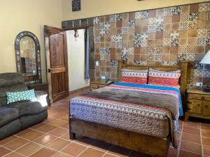 a bedroom with a bed and a couch at Suites Valentina - Cerca de la playa y centro histórico in Loreto