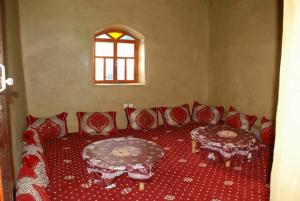 a living room with red chairs and a table at دار اوليم in Annoums