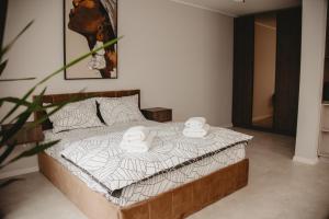 クルジュ・ナポカにあるWhite House Iris Cluj Napoca - Apartament 1のベッドとタオル2枚のある寝室