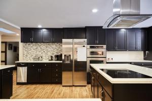 a kitchen with black cabinets and stainless steel appliances at Oceanline 180° home in Federal Way +39 photos