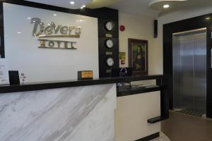 a hotel lobby with a reception counter and clocks at Devera Hotel in Angeles