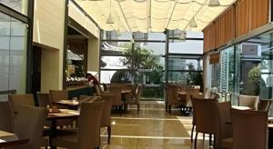 a restaurant with wooden tables and chairs and windows at Lijiang Conifer Lishui Yangguang Hotel in Lijiang +39 photos