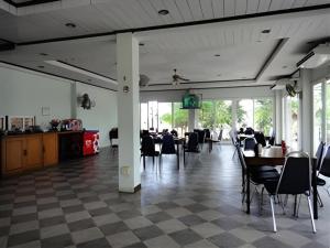 a dining room with tables and chairs and a checkerboard floor at Kasem Garden Hotel Surin in Surin