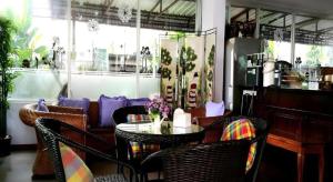 ein Esszimmer mit einem Tisch und einigen Stühlen sowie einem Tisch und einer Liege in der Unterkunft Loei Orchid Hotel in Loei