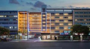 a large building with lights on in a city at Yiwu Guomao Hotel in Yiwu