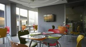 a dining room with a table and colorful chairs at A+ Hotel in Ubon Ratchathani