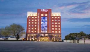 Biway Fashion Hotel - Puyang Lianhua في Puyang: مبنى كبير عليه لافته