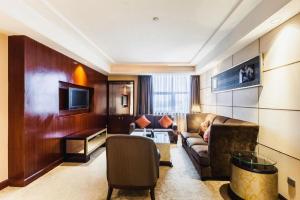 a living room with a couch and a tv at Centenio International Hotel in Foshan