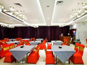 a dining room with tables and red chairs at Nanning Qian Xi International Hotel in Nanning