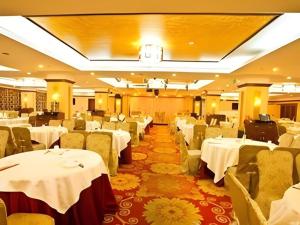 a banquet hall with white tables and chairs at Kui Chong Holiday Hotel in Shenzhen