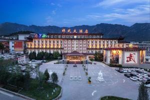 Un gran edificio con un estacionamiento enfrente. en Dengfeng Chanwu Hotel, en zhengzhou