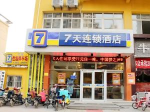a store with people on motorcycles in front of it at 7 Days Inn Liaocheng Railway Station Dongchang Lake in Liaocheng