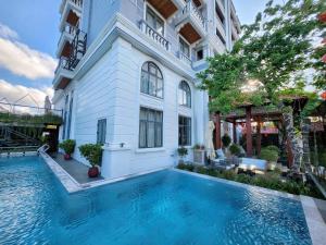 a swimming pool in front of a building at My Son Boutique Hotel & Spa Hoi An in Hoi An