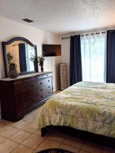 a bedroom with a bed and a dresser with a mirror at Paradise Beach East in Indialantic