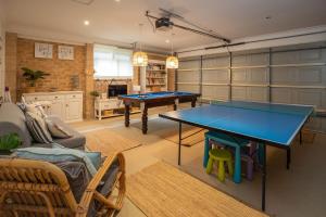una sala de estar con 2 mesas de ping pong. en Luminara Luxury Lakefront, en Smiths Lake