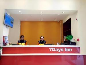 two women are sitting at a reception desk at 7 Days Inn Yingshang Lanxing Building Materials Market in Fuyang