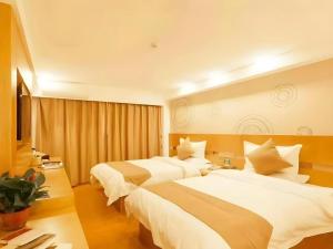 a hotel room with two beds and a table at GreenTree Inn Heze Danxian Shangmaocheng Business Branch in Shan +42 photos