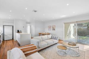 una sala de estar con un sofá y una mesa en 3BR Retreat Mount Duneed, en Grovedale