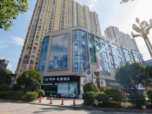 un gran edificio con conos naranjas delante de él en Xana Lite Anqing Yuexi Swan Squre Branch, en Yuexi