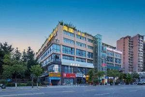 a large building with a lot of windows on a street at IU Hotel Chengdu Jianyang Xiongzhou Plaza in Ziyang