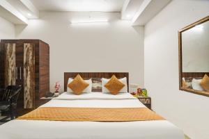 a bedroom with a large bed and a mirror at Hotel Aerotech Near Delhi Airport in New Delhi