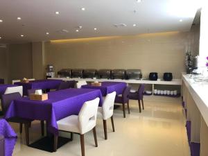 a dining room with purple tables and white chairs at Lavande Hotels Lhasa Municipal Government Tibet University in Lhasa