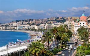 Blick auf eine Stadt mit Palmen und das Meer in der Unterkunft Designer Flat Nice in Nizza