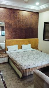 een slaapkamer met een bed met een houten hoofdeinde bij Hotel chhaya in Aurangabad