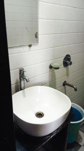 een witte wastafel in een badkamer met een spiegel bij Hotel chhaya in Aurangabad +11 foto's