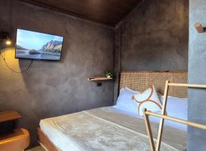 a bedroom with a bed with a tv on the wall at Casa Elia San Juan La Union Beach Cabin in San Juan