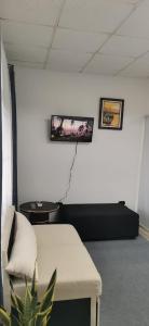 a room with a couch and a tv on the wall at Linda Vibra apartamentos in Buenos Aires