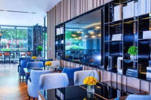 a restaurant with blue chairs and tables and windows at Echarm Hotel Guilin Zhongshan Zhong Road Liangjiang Sihu in Guilin
