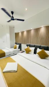 a room with two beds with yellow pillows at GM Residency in Varanasi