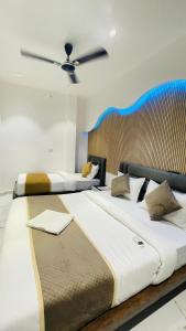 two large beds in a bedroom with a ceiling at GM Residency in Varanasi