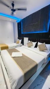 two beds in a room with blue lighting at GM Residency in Varanasi +37 photos