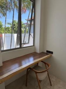 サヌールにあるMaison Bohemeの椅子のある部屋に窓付きの机がある
