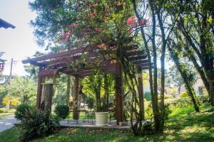 een houten pergola in een park met bomen bij Hotel Pousada do Bosque in Canela