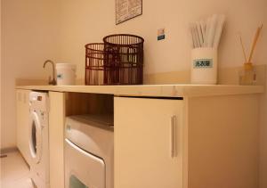 a laundry room with a washing machine under a counter at City Comfort Inn Zhanjiang Middle Renmin Avenue Dingsheng Square in Zhanjiang
