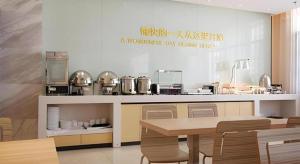 a kitchen with a table and chairs and a counter at City Comfort Inn Lichuan Railway Station Tenglong Cave in Enshi