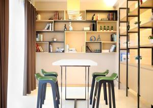 a table and two stools in a room with shelves at City Comfort Inn Suizhou Bingzi Wanda in Suizhou